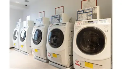 a row of white washing machines in a laundry room at Via Inn Iidabashi Korakuen in Tokyo