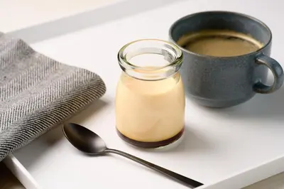 a glass jar of milk next to a cup of coffee at Via Inn Iidabashi Korakuen in Tokyo