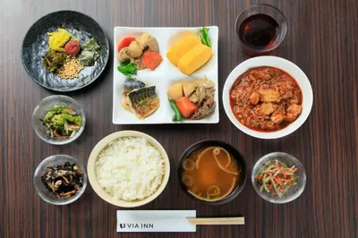 a table with plates of food and bowls of food at Via Inn Akihabara in Tokyo