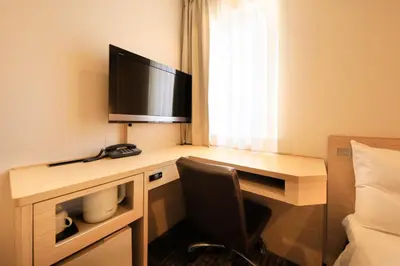 a hotel room with a desk with a television on it at Via Inn Akihabara in Tokyo