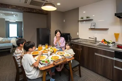 a family sitting at a table eating food at ENT TERRACE Asakusa in Tokyo