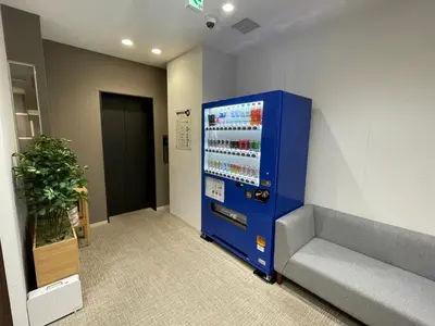 a blue vending machine in a room with a couch at ENT TERRACE Asakusa in Tokyo