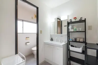a bathroom with a sink and a toilet and a mirror at Otsuka house with 2BR near the Yamanote line in Tokyo