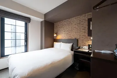 a bedroom with a large white bed and a brick wall at HOTEL TABARD TOKYO - Vacation STAY 62622v in Tokyo
