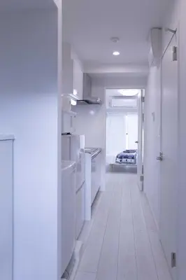 a white kitchen with a hallway with white appliances at japan house sugamo in Tokyo