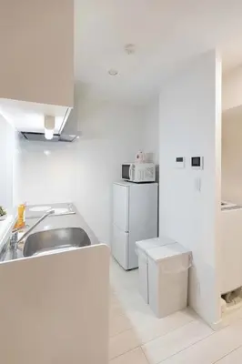 a white kitchen with a sink and a refrigerator at japan house sugamo in Tokyo