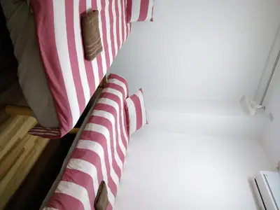 a bed with red and white striped sheets at Ichijuku Ryokan Kaminarimon - Vacation STAY 75757v in Tokyo