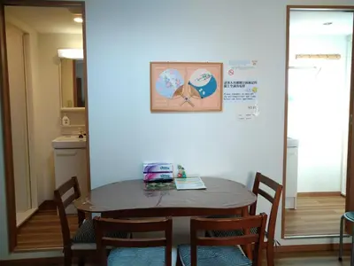 a table and chairs in a room with a wall at Ichijuku Ryokan Kaminarimon - Vacation STAY 75803v in Tokyo