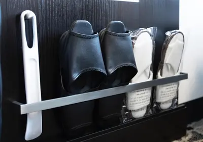 a pair of black boots and other shoes in a drawer at APA Hotel Asakusa Shin Okachimachi Ekimae in Tokyo