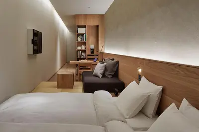a hotel room with a bed and a chair at MUJI HOTEL GINZA in Tokyo