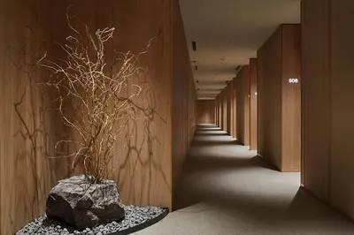 a hallway with a rock and a plant in a vase at MUJI HOTEL GINZA in Tokyo