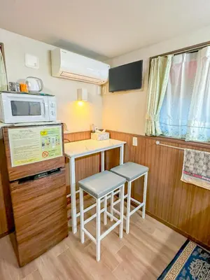 a small kitchen with a table and a microwave at SHINJUKU WARM VILLA I in Tokyo