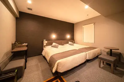 a bedroom with a large bed and a table and chair at Super Hotel Premier Ikebukuro Natural Hot Spring in Tokyo
