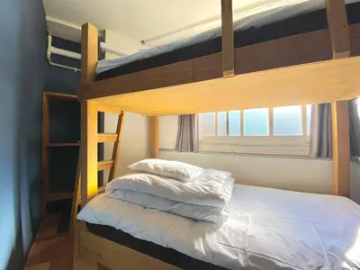 a bedroom with two bunk beds with white sheets at STAY WORK ASAKUSA guest house \u6d45\u8349\u5e97 in Tokyo