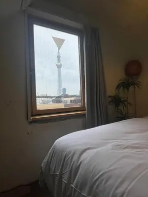 a bedroom with a window with a view of the eiffel tower at STAY WORK ASAKUSA guest house \u6d45\u8349\u5e97 in Tokyo