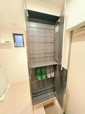 a walk in closet with green shoes on a shelf at japan house itabashi in Tokyo