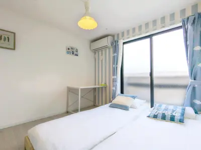 a bedroom with two beds and a large window at japan house itabashi in Tokyo