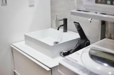 a white bathroom sink with a black phone on it at Pufuka Inn Skytree in Tokyo