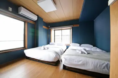three beds in a room with blue walls at Pufuka Inn Skytree in Tokyo