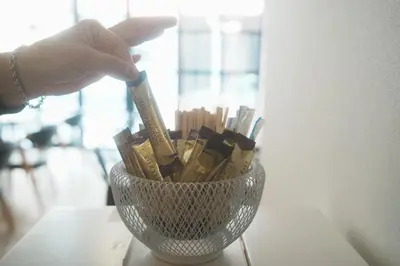 a person is holding a toothbrush in a glass container at Hostel JAZ in Tokyo