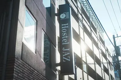 a sign for a store on the side of a building at Hostel JAZ in Tokyo