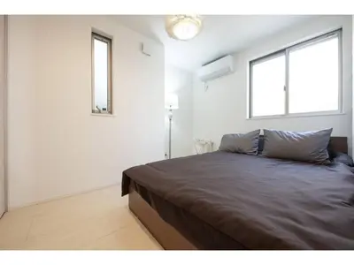 a bedroom with a large bed with two windows at Private Hotel Oshiage - Vacation STAY 81630v in Tokyo