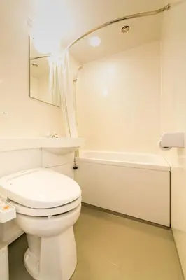 a white bathroom with a toilet and a bath tub at Pearl Hotel Kayabacho in Tokyo