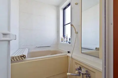 a bathroom with a tub and a sink and a mirror at japan house shinkoiwa guest house in Tokyo