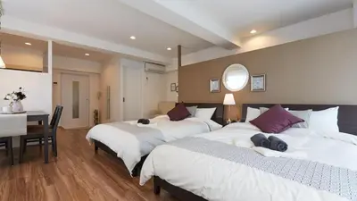 a bedroom with two beds and a desk and a table at HOTEL ESTASIA Ryogoku - Vacation STAY 98929v in Tokyo