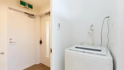 a bathroom with a washer and dryer next to a door at HOTEL ESTASIA Ryogoku - Vacation STAY 98929v in Tokyo