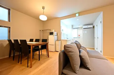 a living room with a couch and a table with chairs at Hotel AZUMA SEE in Tokyo