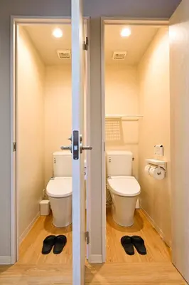 a bathroom with a toilet and a pair of shoes at Hotel AZUMA SEE in Tokyo