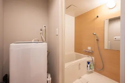 a small bathroom with a shower and a refrigerator at Hotel AZUMA SEE in Tokyo
