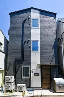 a black brick building with two windows and a door at Hotel AZUMA SEE in Tokyo