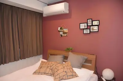 a bedroom with a bed and a red wall at AN HOTEL in Tokyo