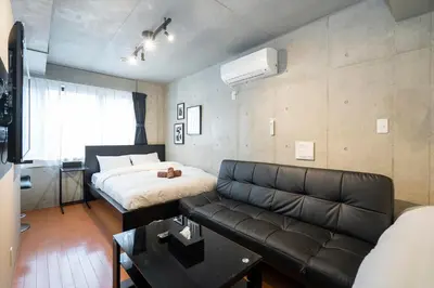 a living room with a couch and a bed at Shinjuku area Industrial Chic apartment Walk 6min To Station in Tokyo
