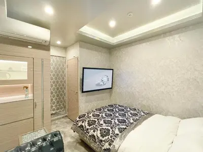 a bedroom with a bed and a tv on the wall at Hotel DIAMOND in Tokyo