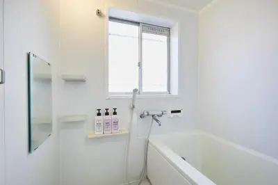 a white bathroom with a tub and a window at Shinjuku area house with 3BR 2mins to Metro on foot in Tokyo