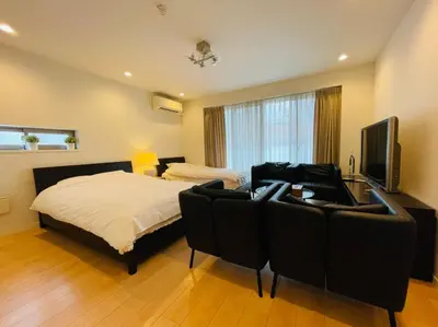 a bedroom with a bed and a couch and a television at SALON\u6e0b\u8c375B in Tokyo