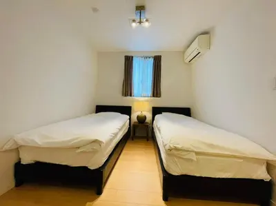 two beds in a small room with a window at SALON\u6e0b\u8c375B in Tokyo