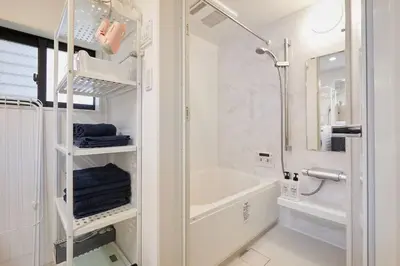 a white bathroom with a tub and a shower at Shinkoiwa house at JR line.Easy to airport&Disney. in Tokyo