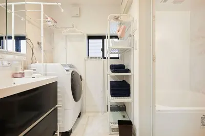 a white bathroom with a sink and a shelf at Shinkoiwa house at JR line.Easy to airport&Disney. in Tokyo