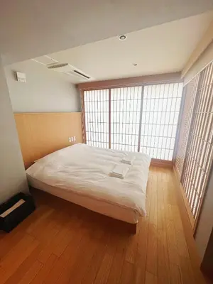 a large bed in a room with large windows at Nplus Tokyo Akihabara Premium in Tokyo