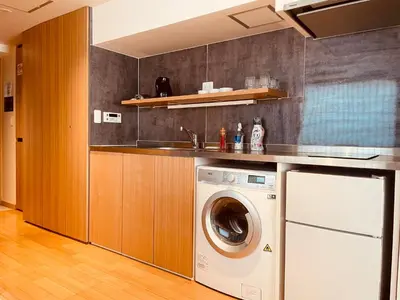 a kitchen with a washing machine and a sink at Nplus Tokyo Akihabara Premium in Tokyo