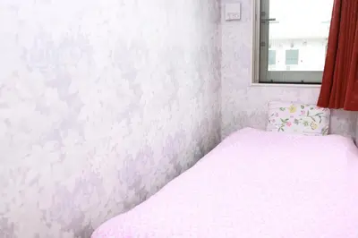 a small bedroom with a bed and a mirror at Tokyo Guest House 2020 in Tokyo