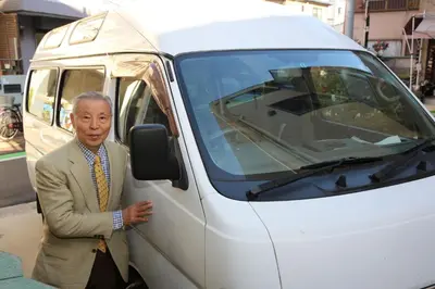 a man in a suit standing next to a van at Tokyo Guest House 2020 in Tokyo
