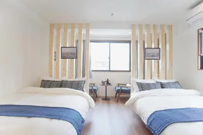a bedroom with two beds and a window at dandelion house in Tokyo