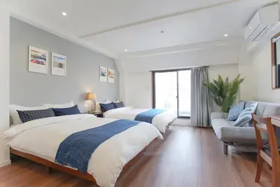 a bedroom with two beds and a couch at dandelion house in Tokyo
