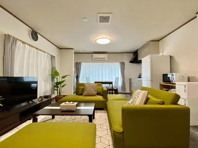 a living room with green furniture and a tv at ONE HOUSE SHINKOIWA - Vacation STAY 26055v in Tokyo