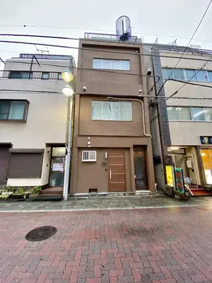 a building with a brown door on a brick street at ONE HOUSE SHINKOIWA - Vacation STAY 26055v in Tokyo